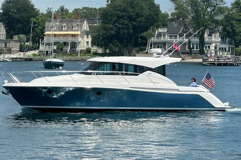 The Image of 2017 Tiara Yachts C39 Coupe cruising on a scenic waterfront with historic homes. - 0