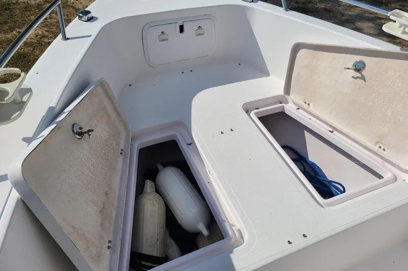 Slide: The Image of 2005 Pro-Line 24 Sport boat storage compartments with open hatches and visible equipment. - 11