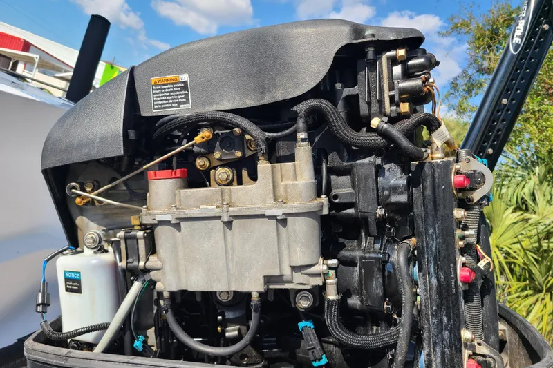 Slide: The Image of Close-up of a 2005 Pro-Line 24 Sport boat engine, showcasing intricate mechanical components. - 28