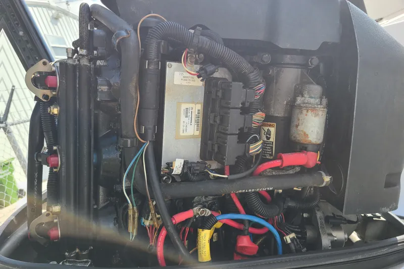 Slide: The Image of Close-up of a 2005 Pro-Line 24 Sport boat engine with visible wiring and components. - 30