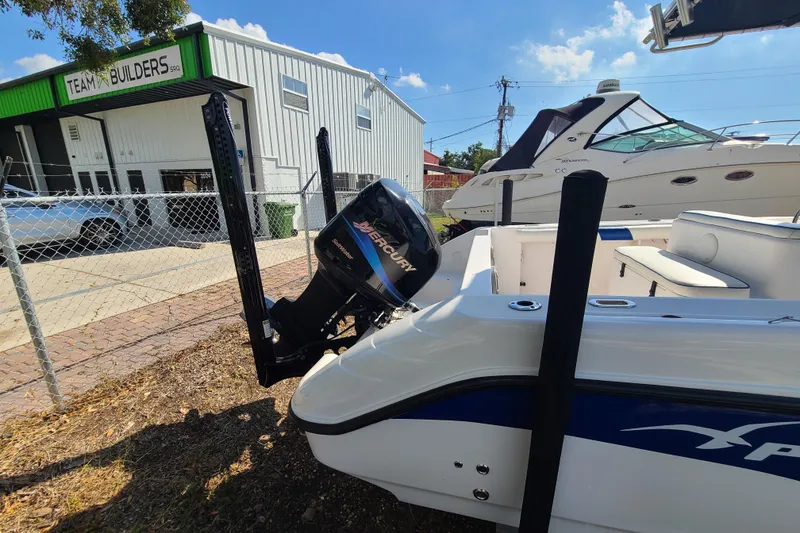 Slide: The Image of 2005 Pro-Line 24 Sport boat with Mercury engine, parked near a building. - 5