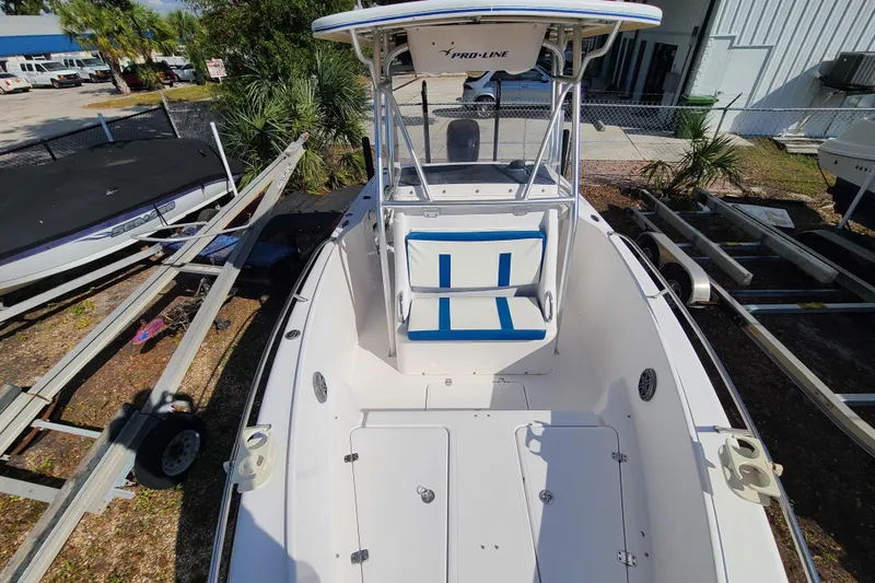 Slide: The Image of 2005 Pro-Line 24 Sport boat with blue and white seating, docked outdoors. - 9
