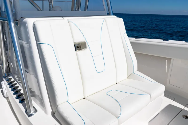 Slide: The Image of 2024 SeaVee 390B boat with white cushioned seating, blue stitching, and ocean backdrop. - 20