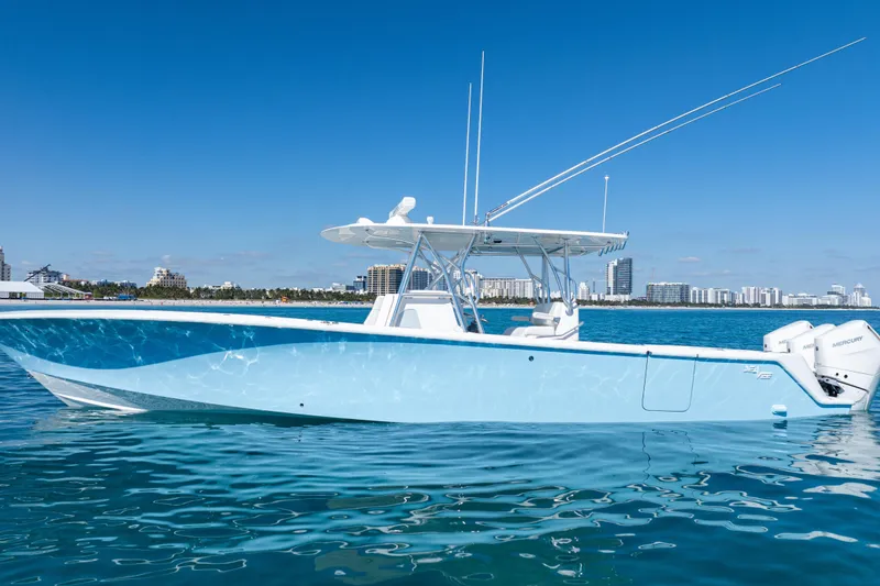 Slide: The Image of 2024 SeaVee 390B boat with triple Mercury engines on calm water, city skyline in background. - 5