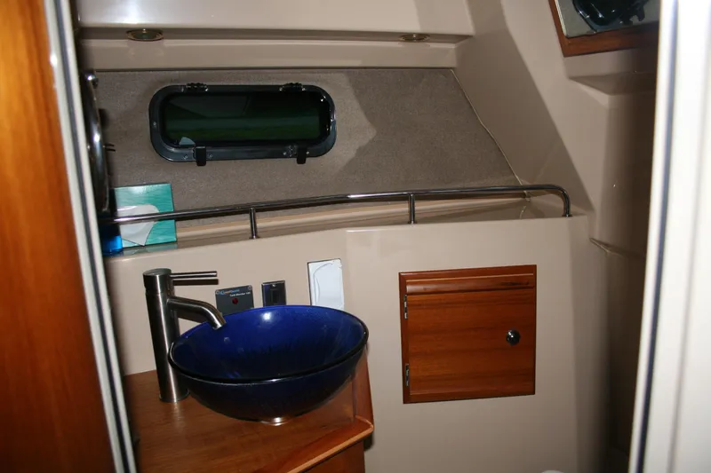Slide: The Image of 2019 Ranger Tugs R-27 boat bathroom with blue sink and wooden cabinet. - 10