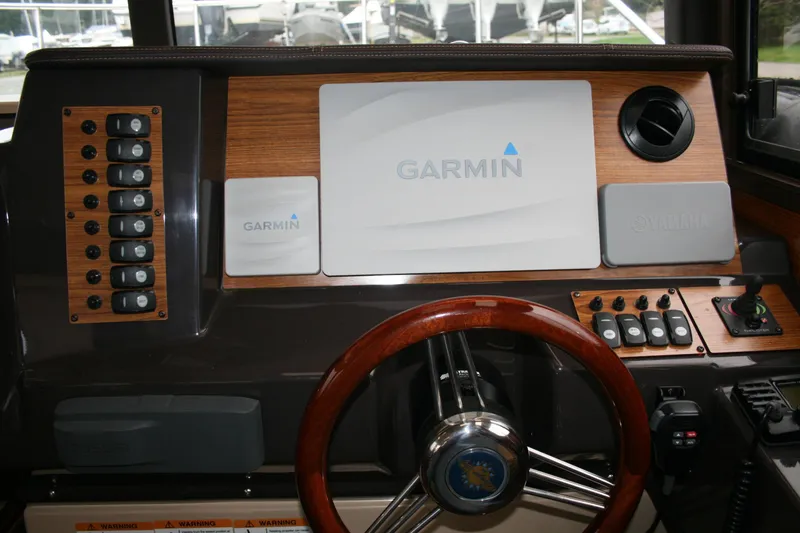 Slide: The Image of 2019 Ranger Tugs R-27 helm with Garmin navigation system and wooden steering wheel. - 3