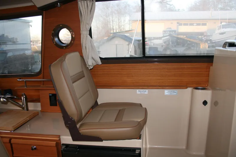 Slide: The Image of 2019 Ranger Tugs R-27 interior with tan seating and wood accents. - 5