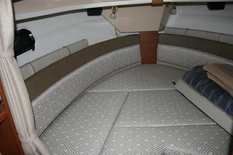 Slide: The Image of 2019 Ranger Tugs R-27 cabin interior with patterned cushions and cozy bedding. - 8