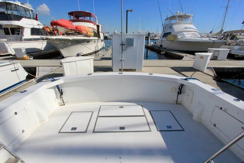 Slide: The Image of 1982 Bertram 35 Flybridge yacht docked at marina, spacious deck view. - 6