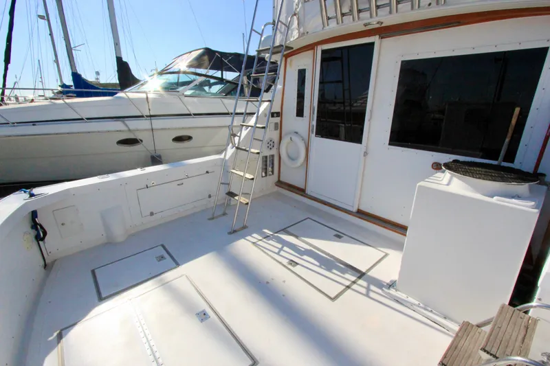 Slide: The Image of 1982 Bertram 35 Flybridge yacht deck with ladder and storage compartments. - 3