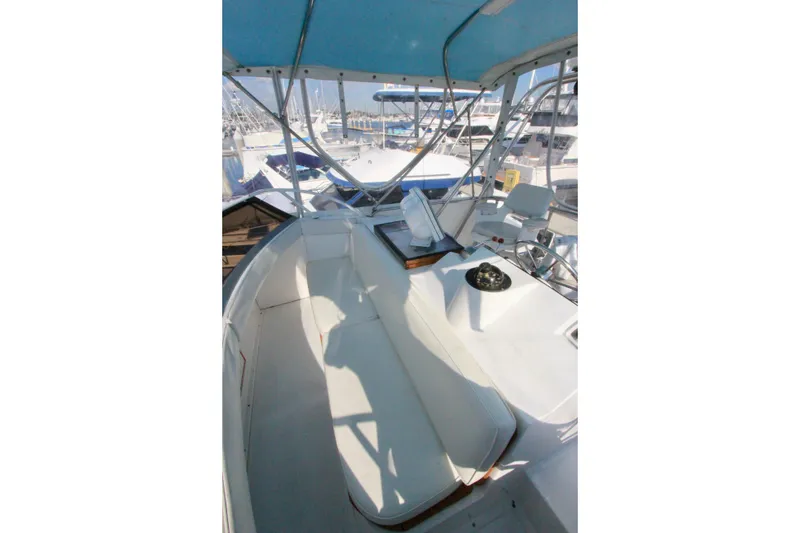 Slide: The Image of 1982 Bertram 35 Flybridge interior with seating and helm, docked at marina. - 36