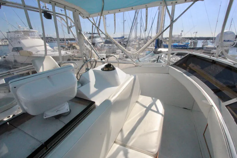 Slide: The Image of 1982 Bertram 35 Flybridge interior with marina view, showcasing helm and seating area. - 37