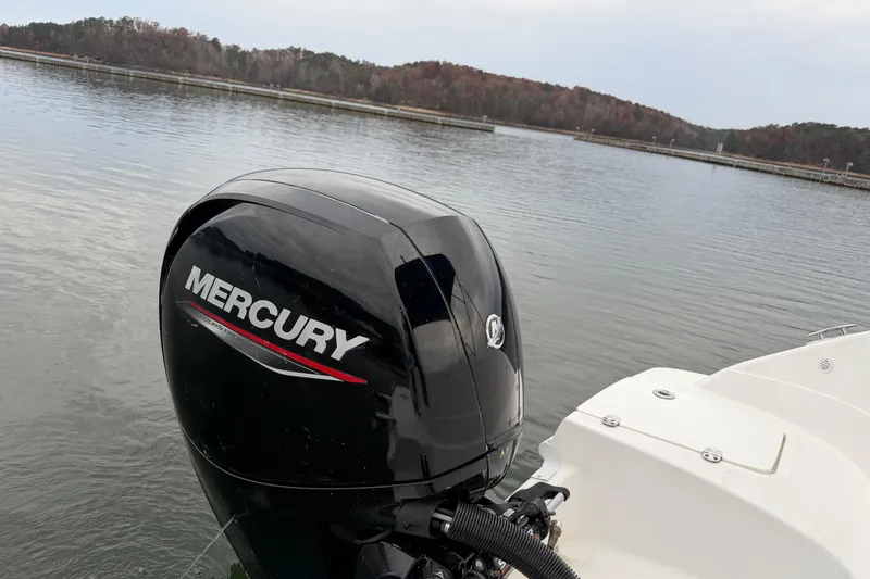 Slide: The Image of 2021 Hurricane SunDeck Sport 192 RL OB with Mercury outboard motor on a serene lake. - 12