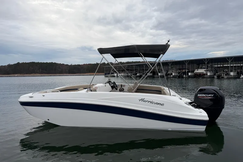 Slide: The Image of 2021 Hurricane SunDeck Sport 192 RL OB boat on calm water, with Mercury outboard motor. - 5