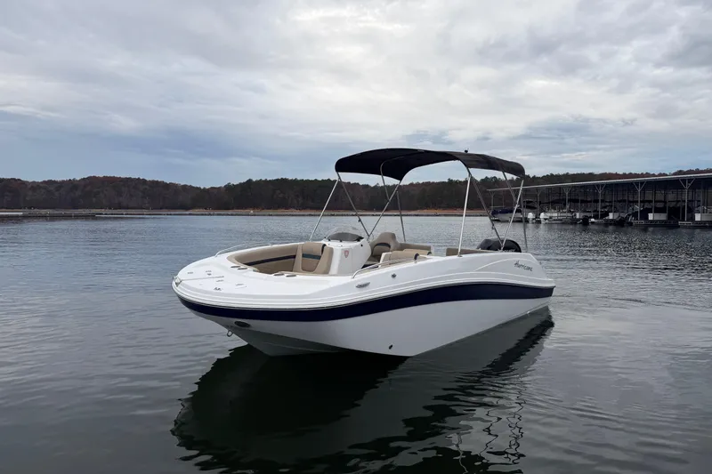 Slide: The Image of 2021 Hurricane SunDeck Sport 192 RL OB boat on calm water, overcast sky. - 6