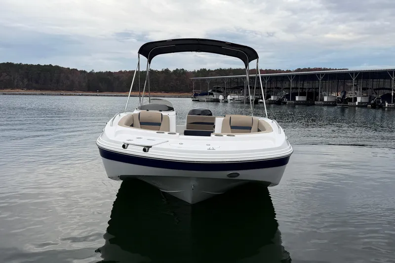 Slide: The Image of 2021 Hurricane SunDeck Sport 192 RL OB boat on calm water near marina. - 7