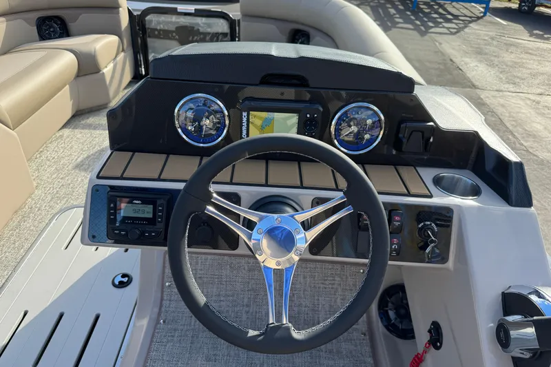 Slide: The Image of 2026 Premier 230 SunSation RF boat dashboard with steering wheel and navigation controls. - 16