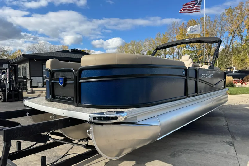 Slide: The Image of 2026 Premier 230 SunSation RF pontoon boat on trailer, under blue sky. - 2