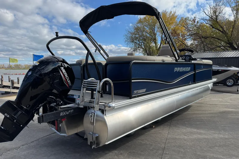 Slide: The Image of 2026 Premier 230 SunSation RF pontoon boat with Mercury engine, docked by a lake. - 5