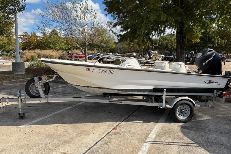 Slide: The Image of 2008 Boston Whaler 150 Sport boat on trailer in parking lot. - 10