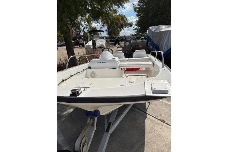 Slide: The Image of 2008 Boston Whaler 150 Sport boat on trailer, parked outdoors. - 2