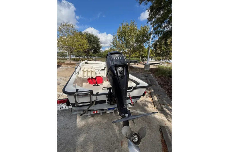 Slide: The Image of 2008 Boston Whaler 150 Sport boat with outboard motor, parked on a trailer. - 9