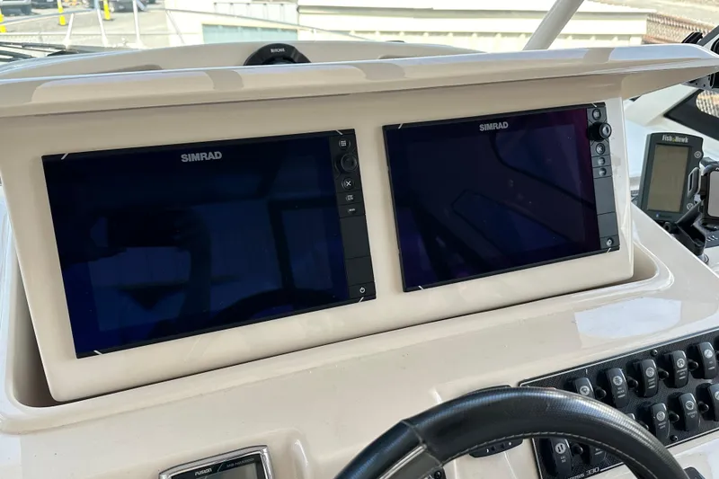 Slide: The Image of 2017 Grady-White Express 330 helm with dual Simrad displays and control panel. - 14