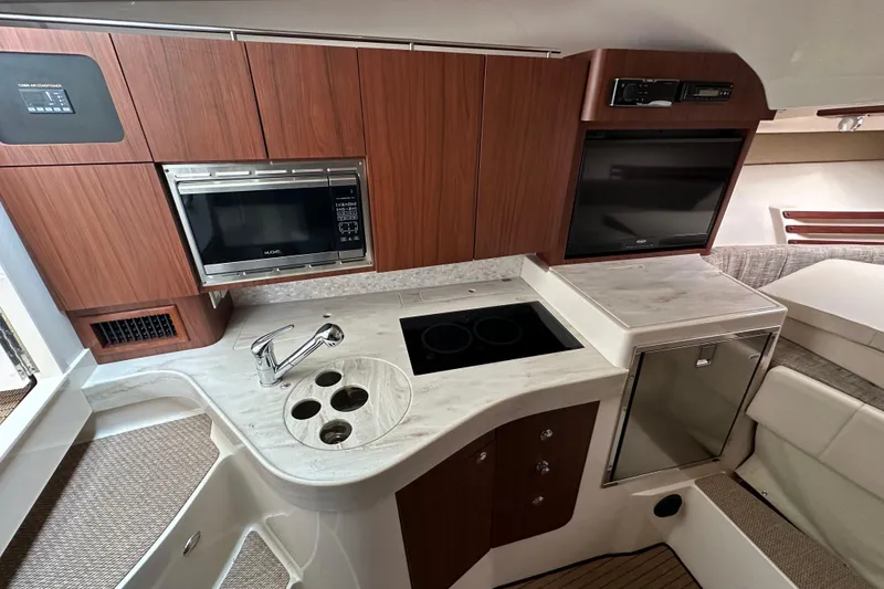 Slide: The Image of 2017 Grady-White Express 330 interior kitchen with microwave, stove, and sink. - 21