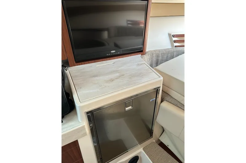 Slide: The Image of 2017 Grady-White Express 330 interior with TV and compact refrigerator. - 8