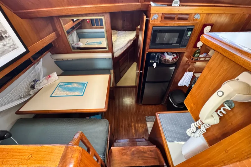 Slide: The Image of 1987 Californian 43 Cockpit MY interior with dining area, kitchenette, and wood finishes. - 11