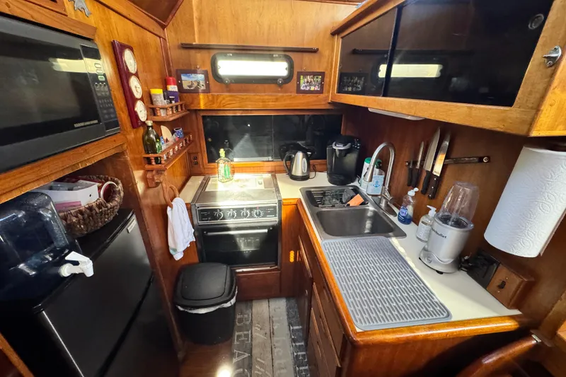 Slide: The Image of 1987 Californian 43 Cockpit MY kitchen with wooden cabinetry, appliances, and compact layout. - 12