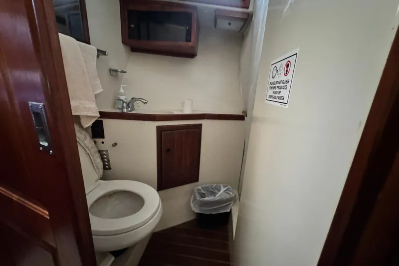 Slide: The Image of 1987 Californian 43 Cockpit MY bathroom with toilet, sink, and wooden cabinetry. - 14