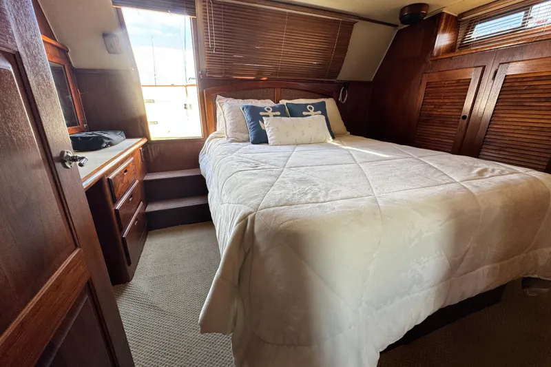 Slide: The Image of Cozy bedroom in 1987 Californian 43 Cockpit MY yacht with nautical decor and wooden accents. - 21