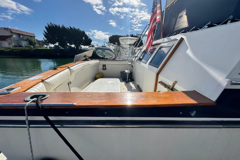 Slide: The Image of 1987 Californian 43 Cockpit MY yacht docked, featuring spacious cockpit and American flag. - 3