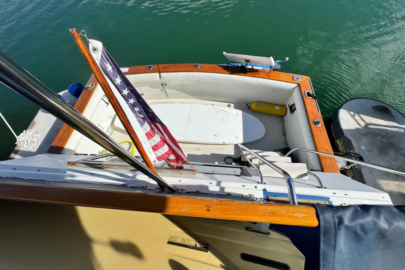 Slide: The Image of 1987 Californian 43 Cockpit MY boat with American flag, docked on calm water. - 8