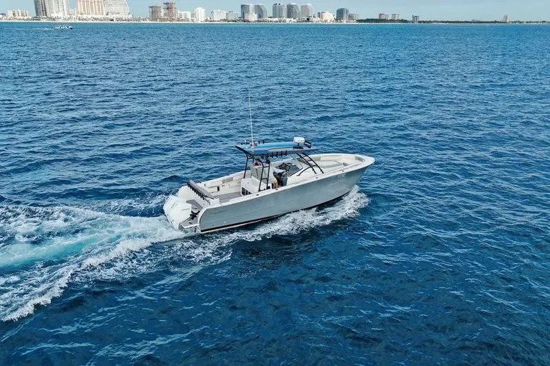 Slide: The Image of A 2025 SeaWell 345XL boat cruising on open blue water near a city skyline. - 4