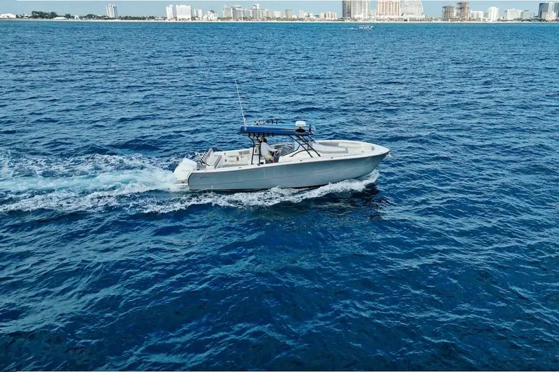 Slide: The Image of A 2025 SeaWell 345XL boat cruising on open blue water near a city skyline. - 5