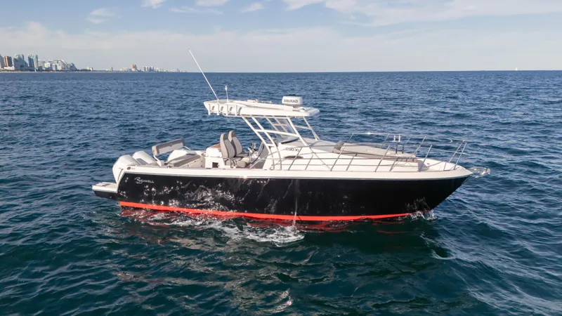 Slide: The Image of 2025 SeaWell 290XL boat cruising on open ocean with city skyline in background. - 15