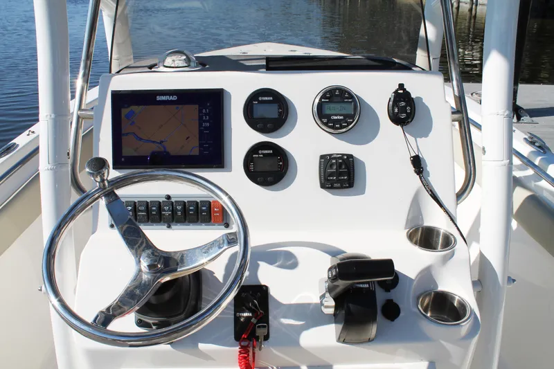 Slide: The Image of 2024 Key West 203 FS boat dashboard with steering wheel and navigation instruments. - 12