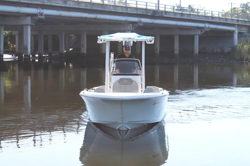 Slide: The Image of 2024 Key West 203 FS boat navigating under a bridge on calm water. - 2