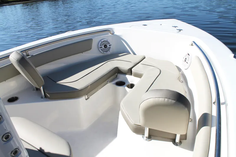 Slide: The Image of 2024 Key West 203 FS boat interior with cushioned seating and cup holders by the water. - 22