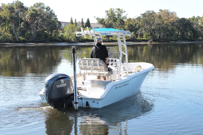 Slide: The Image of 2024 Key West 203 FS boat cruising on a calm river with Yamaha engine. - 5