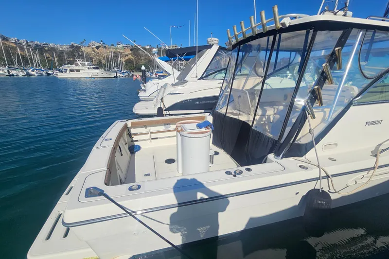 Slide: The Image of 2001 Pursuit 3000 Express boat docked in a marina under clear blue skies. - 10