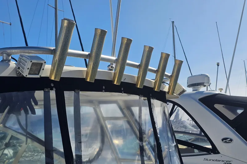 Slide: The Image of 2001 Pursuit 3000 Express boat with rod holders and radar, docked under clear blue sky. - 11