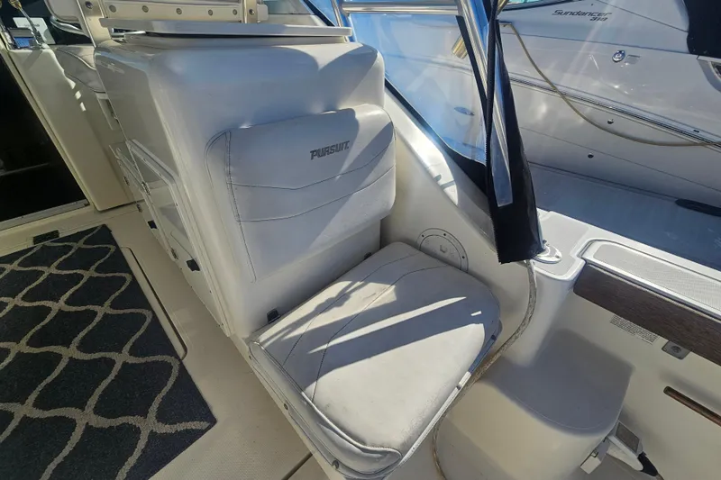 Slide: The Image of 2001 Pursuit 3000 Express boat interior with cushioned seating and nautical decor. - 12