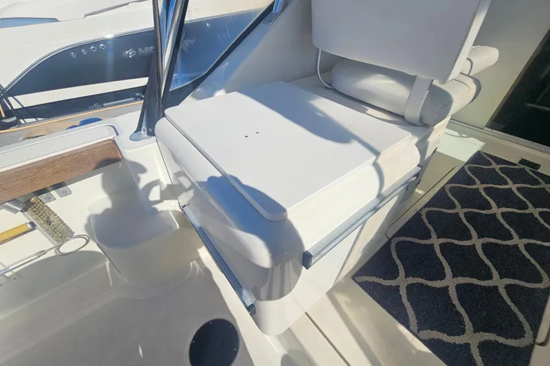 Slide: The Image of 2001 Pursuit 3000 Express boat interior with white seating and patterned carpet. - 14