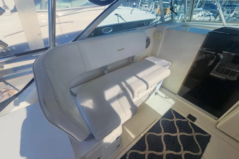 Slide: The Image of 2001 Pursuit 3000 Express boat interior with cushioned seating and nautical decor. - 15