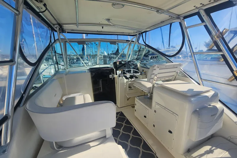 Slide: The Image of 2001 Pursuit 3000 Express boat interior with helm, seating, and clear windows. - 16