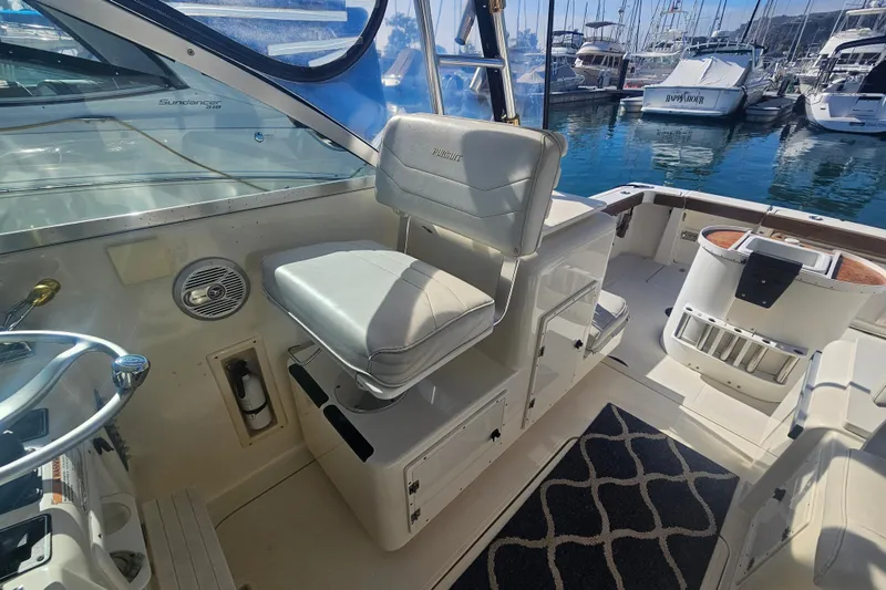 Slide: The Image of 2001 Pursuit 3000 Express boat interior with helm seat and marina view. - 17