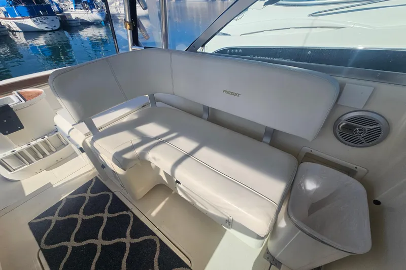 Slide: The Image of Interior of a 2001 Pursuit 3000 Express boat with white seating and nautical decor. - 18